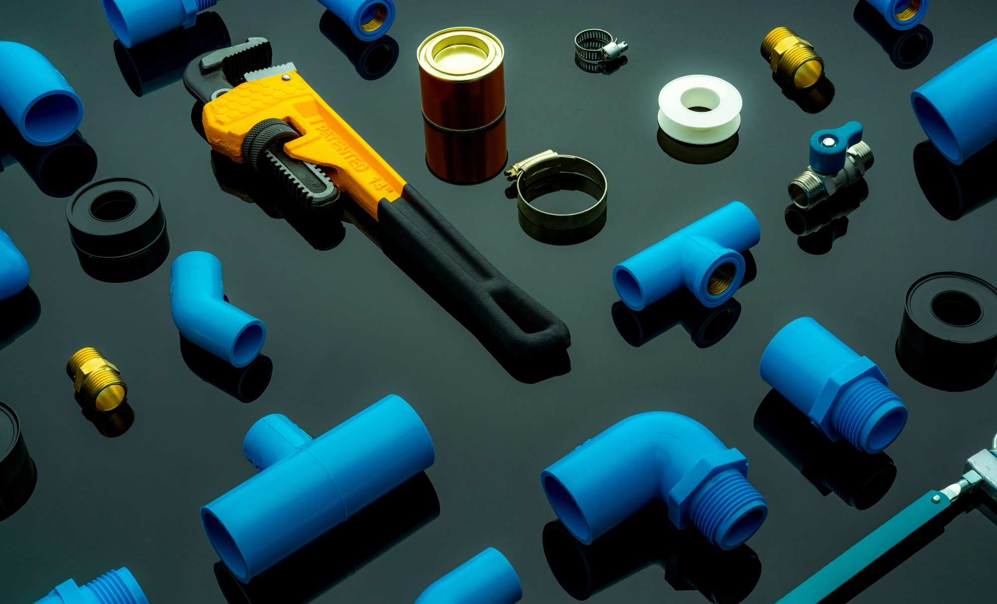 Plumbing tools. Plumber equipment. Blue PVC pipe fittings, glue can, and monkey pipe wrench. House